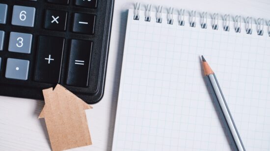 Cardboard,Cutout,House,,Calculator,And,Pencil,On,Blank,Sheet,Of