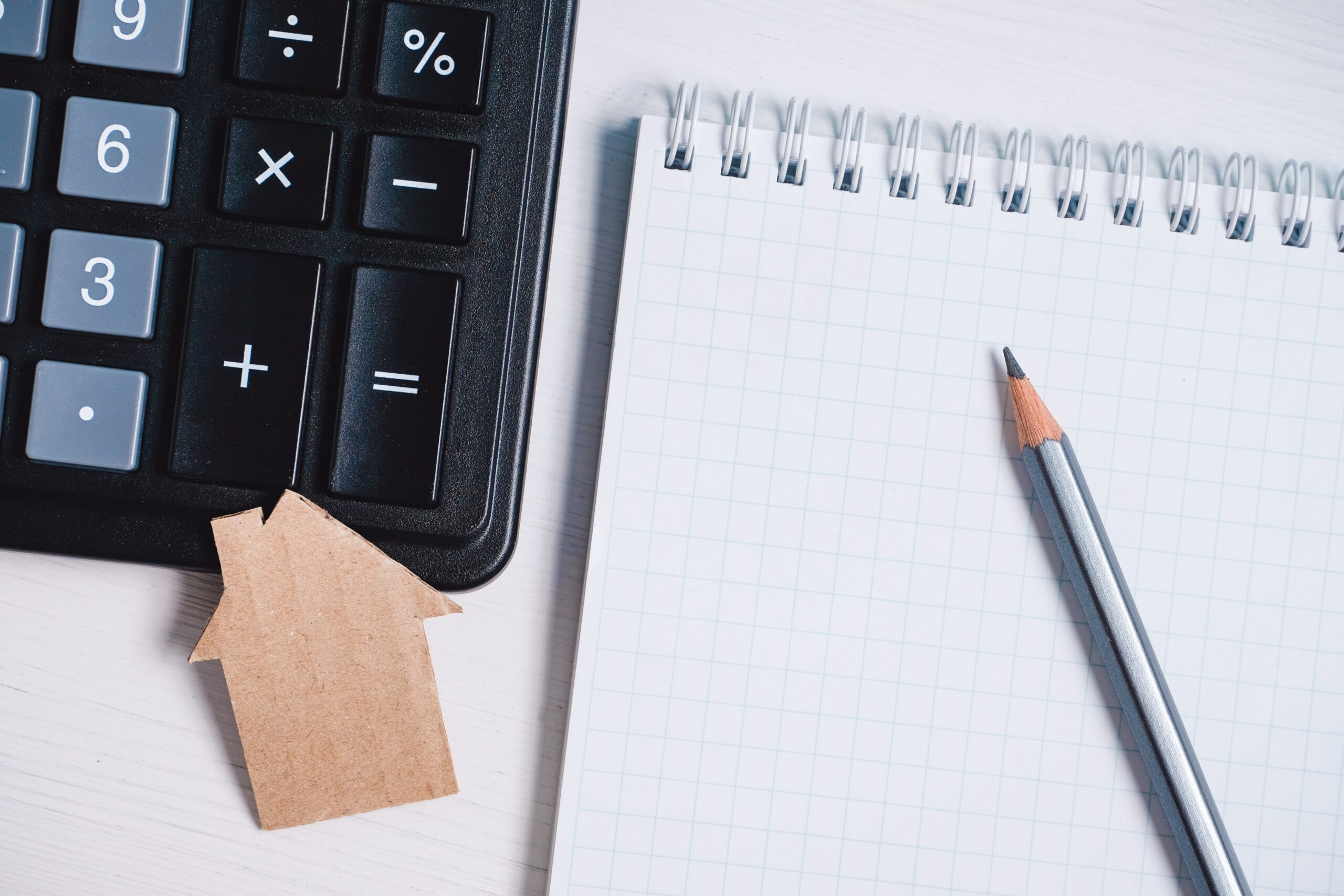 Cardboard,Cutout,House,,Calculator,And,Pencil,On,Blank,Sheet,Of