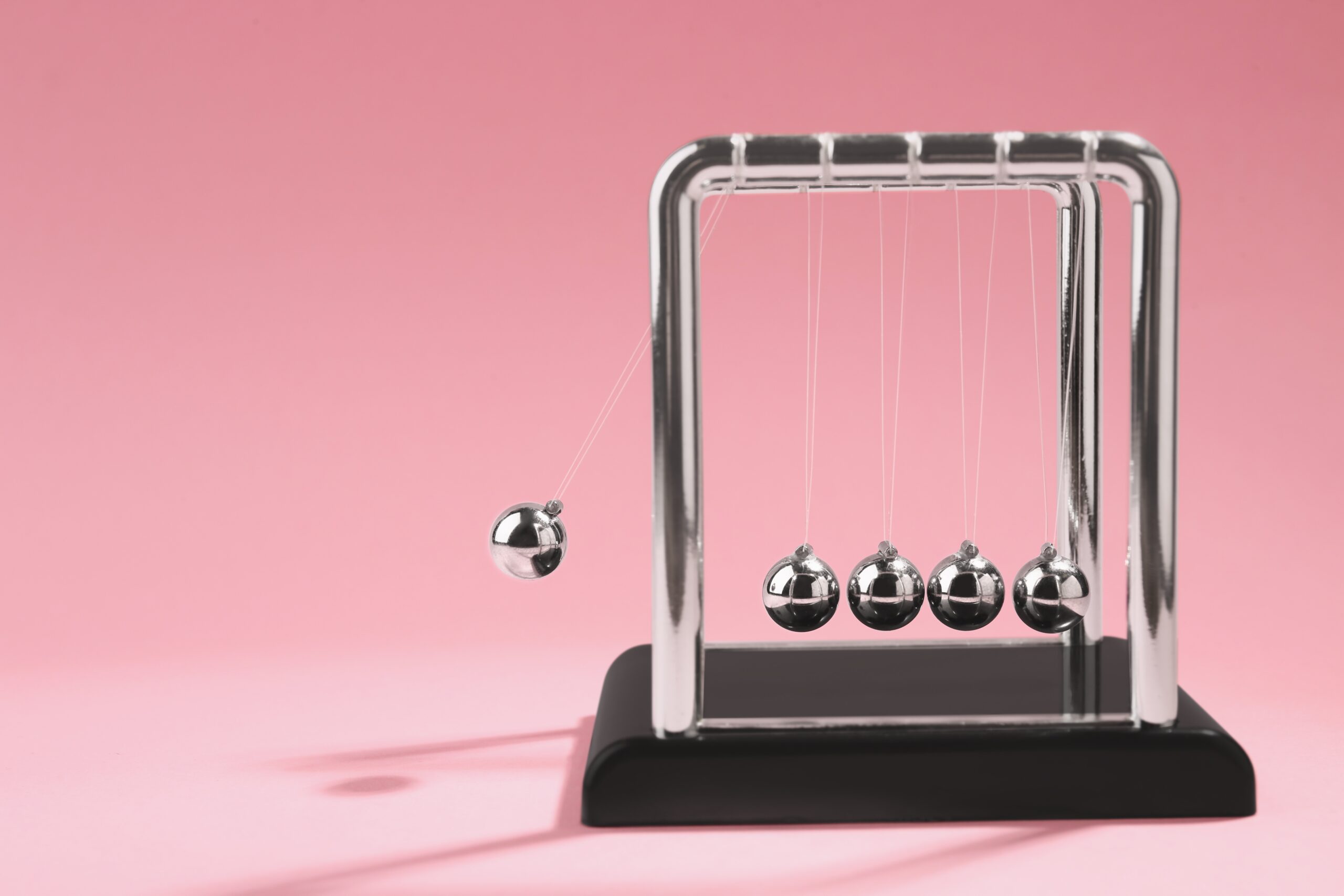 Newton's,Cradle,On,Pink,Background,,Space,For,Text.,Physics,Law